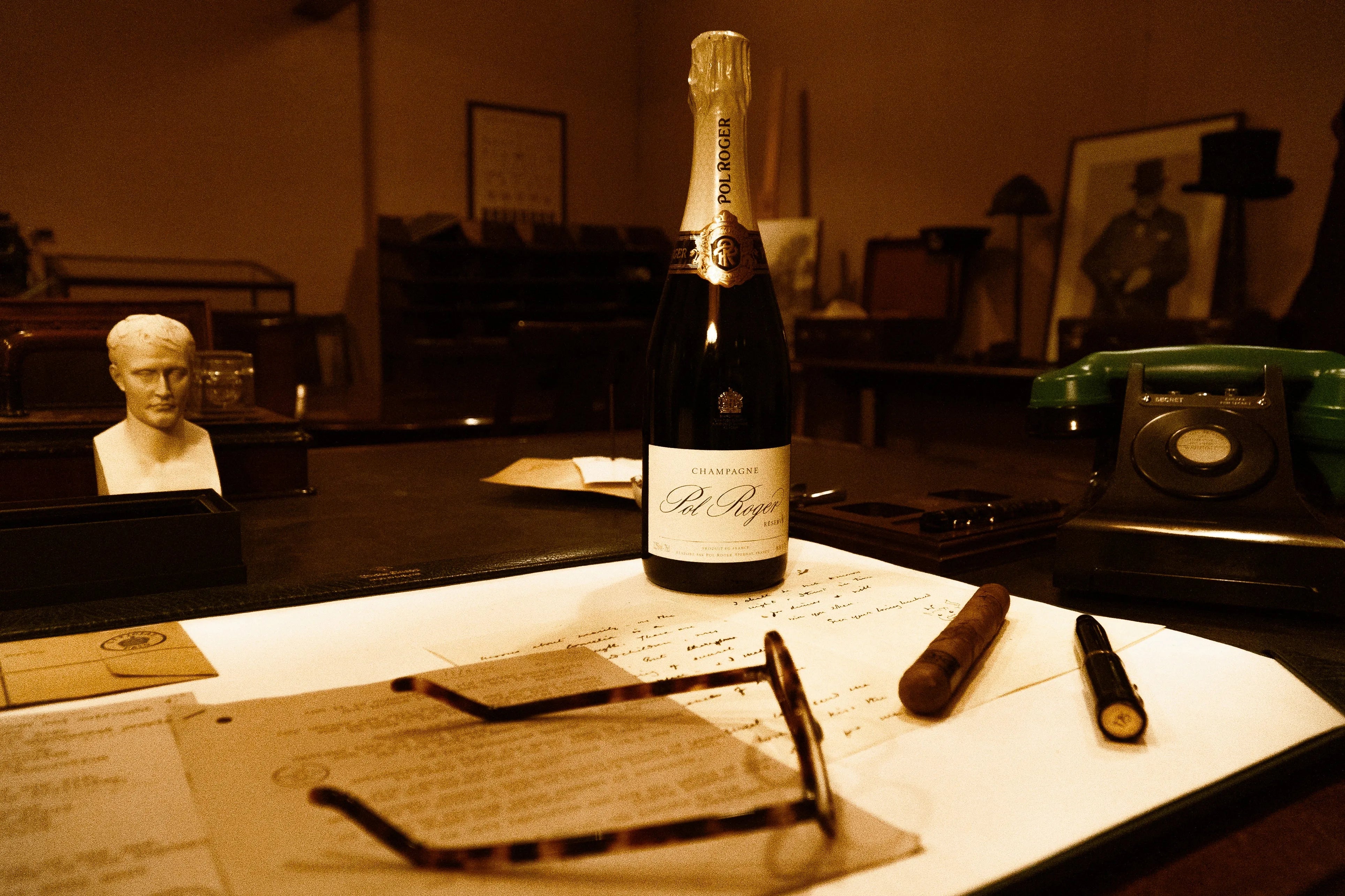 The Pol Roger pen capped on a desk beside a bottle of Pol Roger champagne